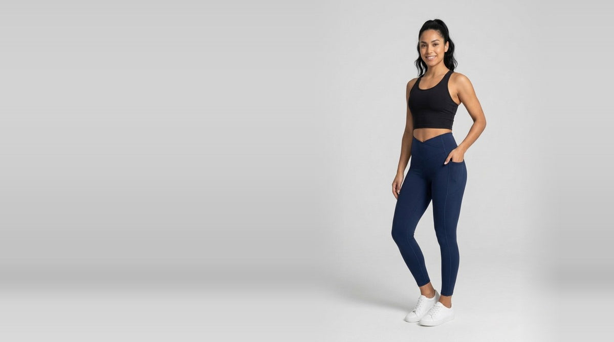 Mujer con leggings azul marino y top deportivo negro en estudio