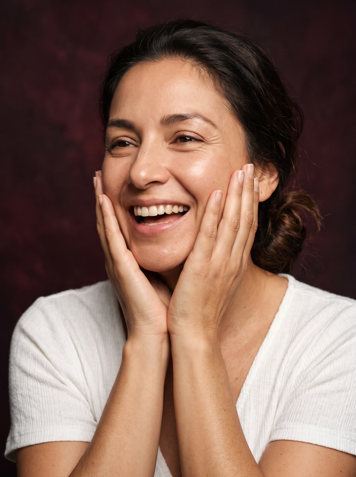 Mujer sonriendo con las manos en las mejillas